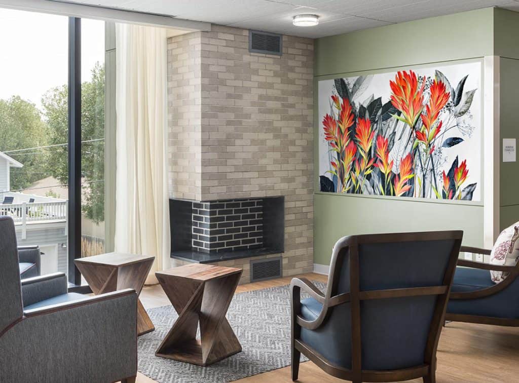 Nature-inspired mural “Indian Paintbrush Flowers” by Yulia Avgustinovich for a senior living community in Jackson, Wyoming, featuring bold red and orange wildflowers.