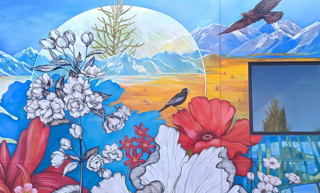 Detail of public art mural at Space to Create in Ridgway, CO with Lark Bunting, Colorado state bird, rocky mountains and poppy flowers.