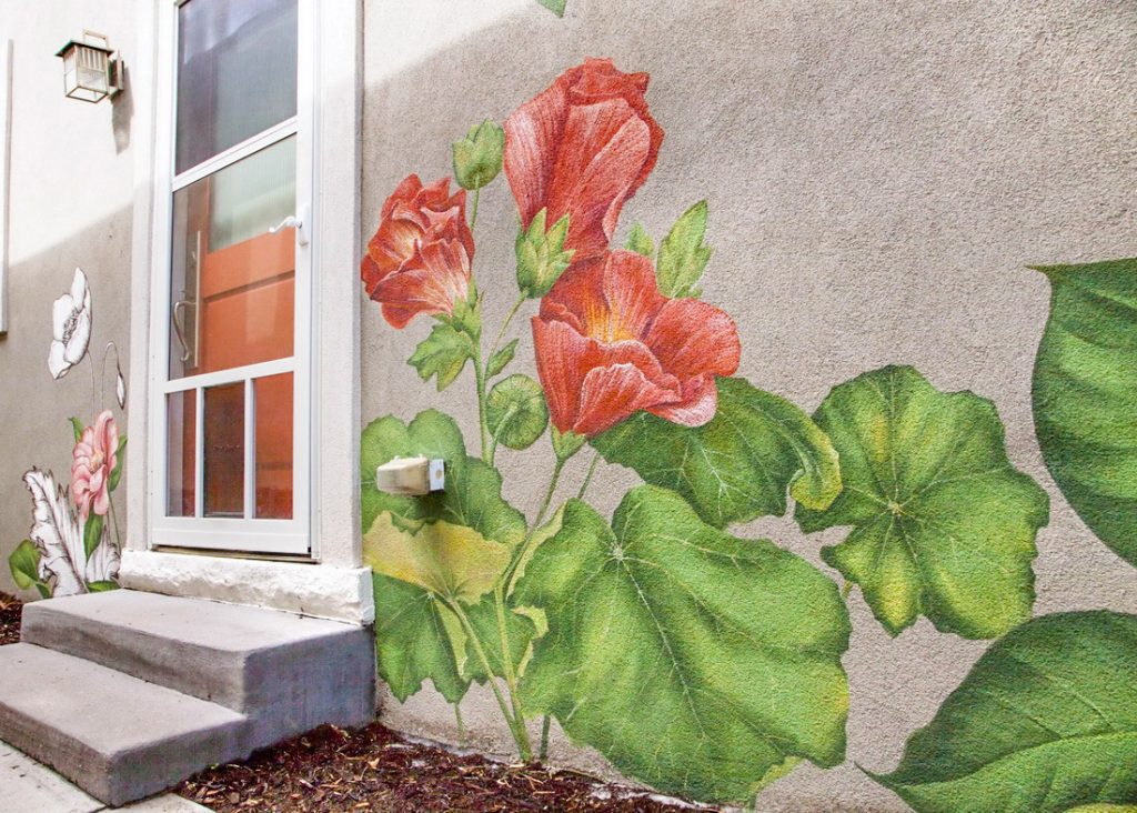 Close-up detail of a floral mural featuring realistic flowers blended with black-and-white etched botanical textures.