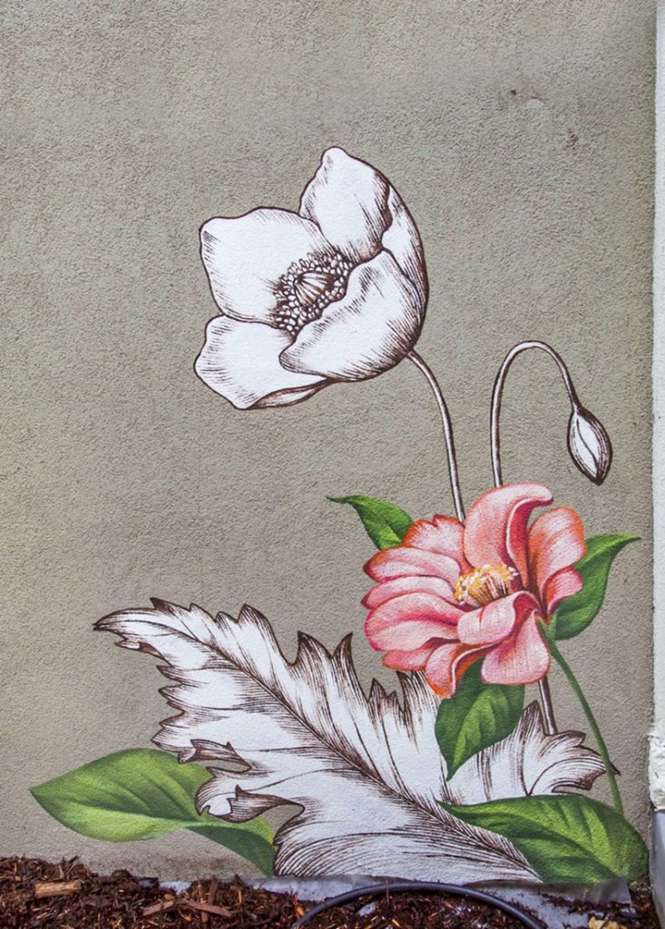 Close-up detail of a floral mural featuring realistic flowers blended with black-and-white etched botanical textures.