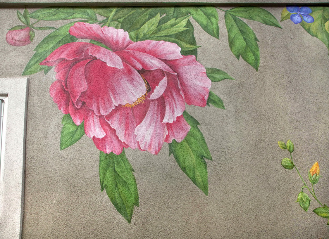 Close-up detail of a floral mural featuring realistic flowers blended with black-and-white etched botanical textures.