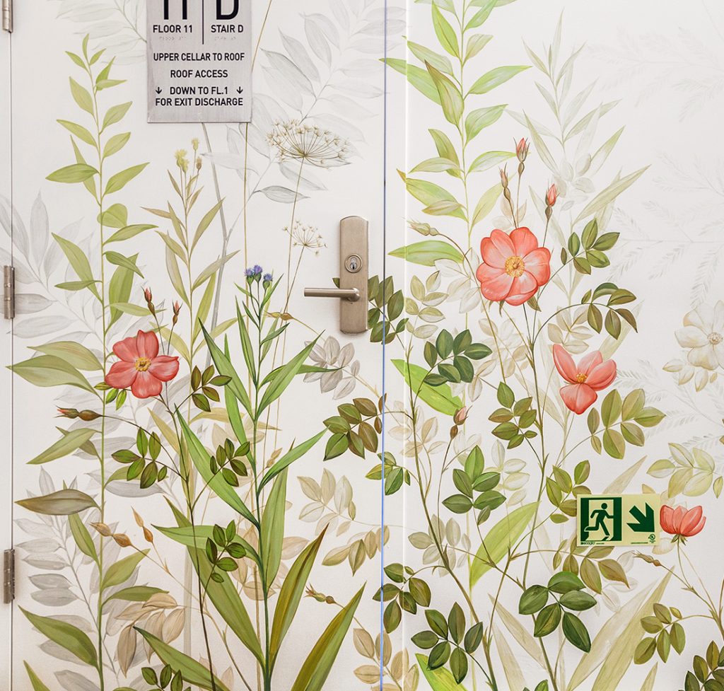 Floral mural in a Manhattan office building staircase connecting the workspace to a rooftop terrace, created for Westcap COI featuring wild briar roses on the door.