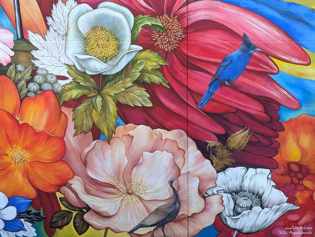 Detail of public art mural at Space to Create in Ridgway, CO with blue jay, wild turkey, poppy flower and wild rose.