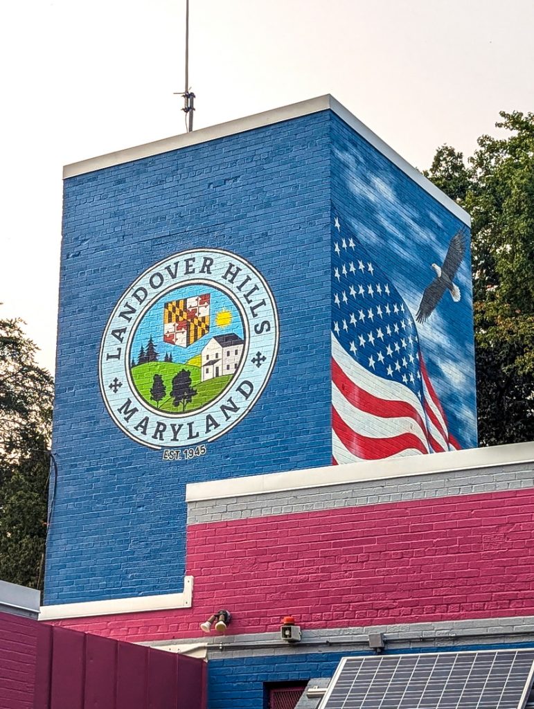Symbolic public art mural on the Town Hall tower in Landover Hills, Maryland, featuring state symbols, the American flag with bald eagle, and the town seal