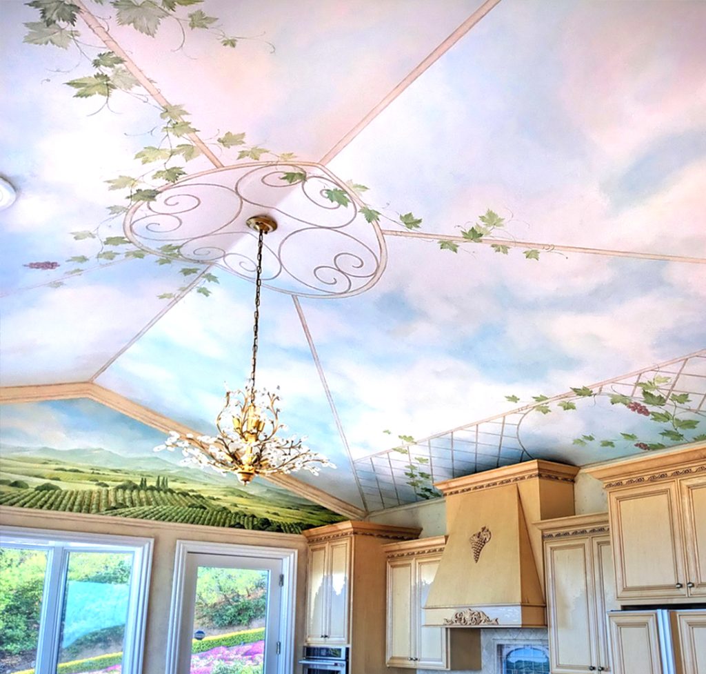 Private kitchen mural by Yulia Avgustinovich in California, featuring a painted sky ceiling with grapevines on a trellis and views of Italian vineyard landscapes.