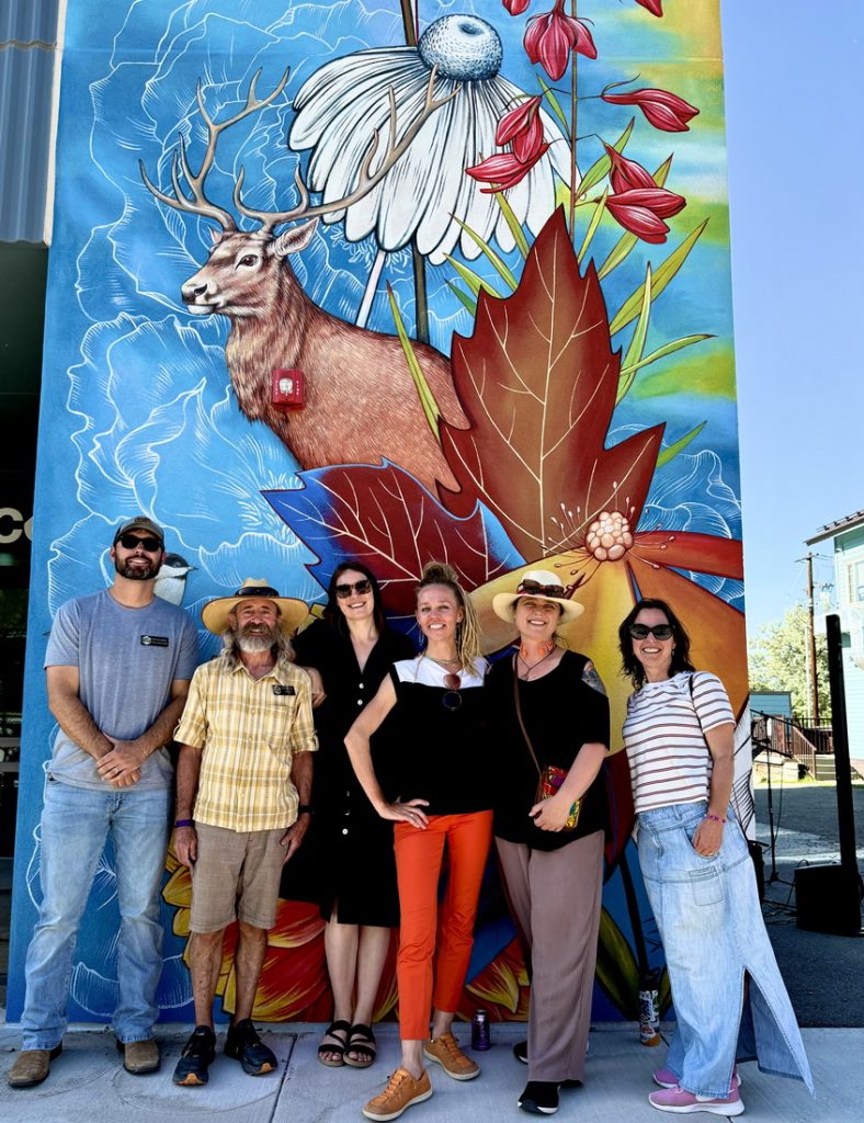 Yulia Avgustinovich and community members in front of Public art mural at Space to Create in Ridgway, Colorado, 