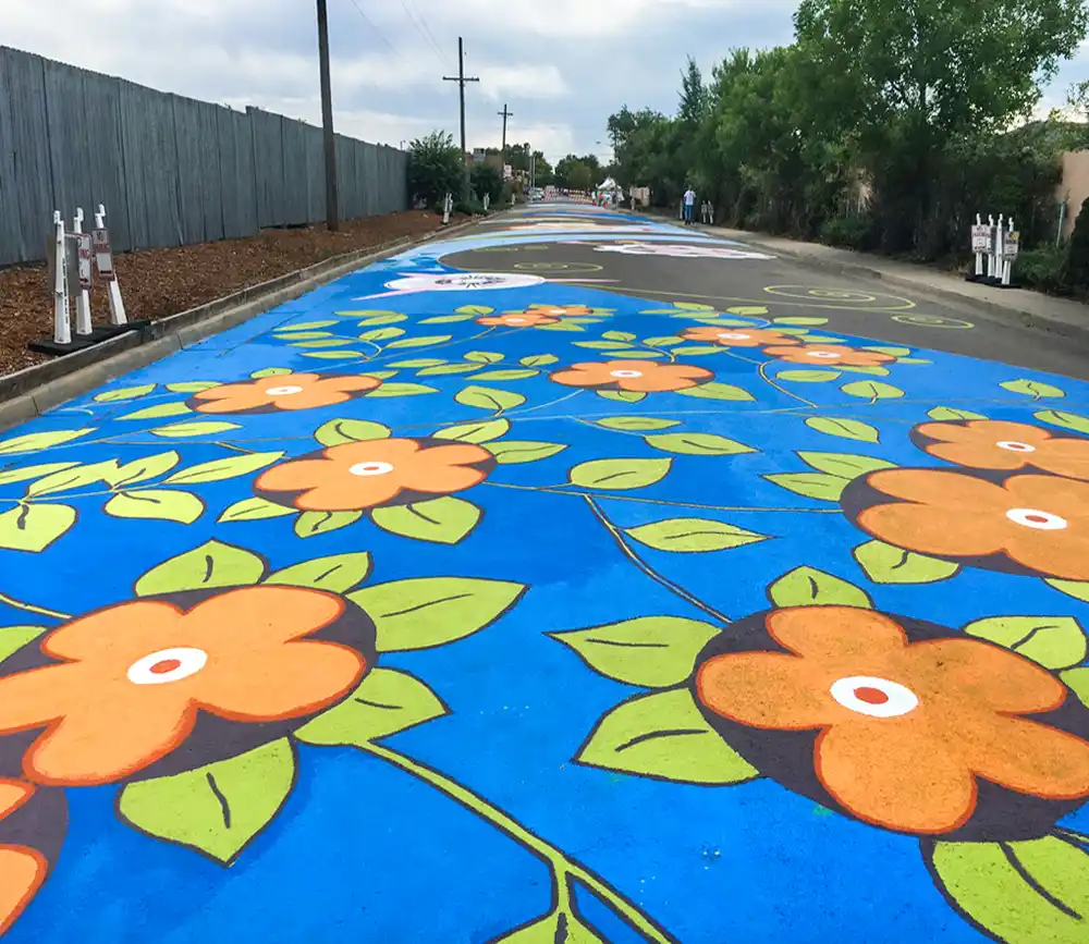 Close-up detail of painted asphalt mural showing graphic elements and street-marking paint texture.