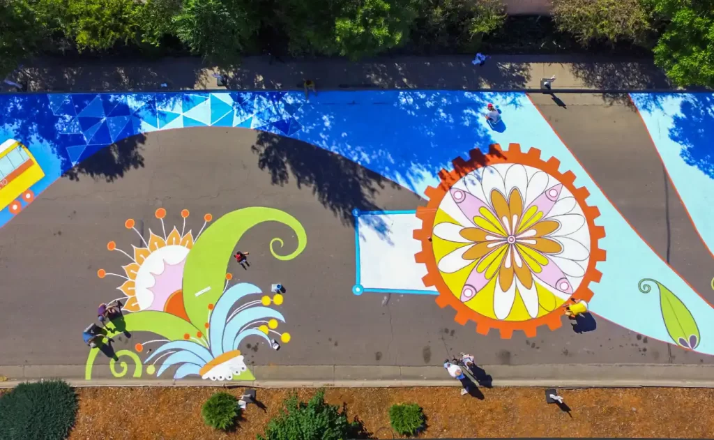Close-up detail of painted asphalt mural showing graphic elements and street-marking paint texture.