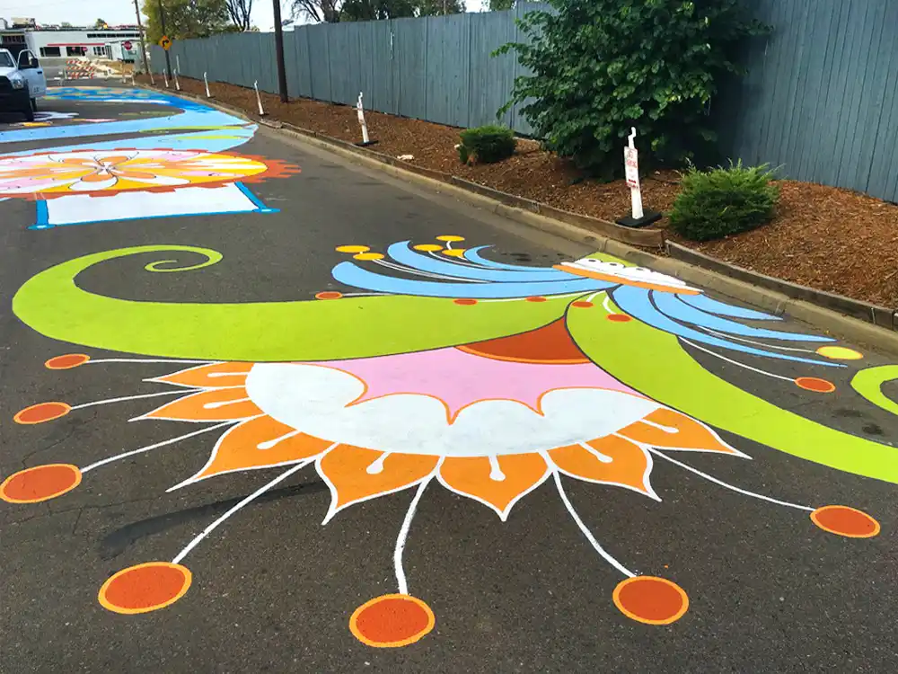 Close-up detail of painted asphalt mural showing graphic elements and street-marking paint texture.
