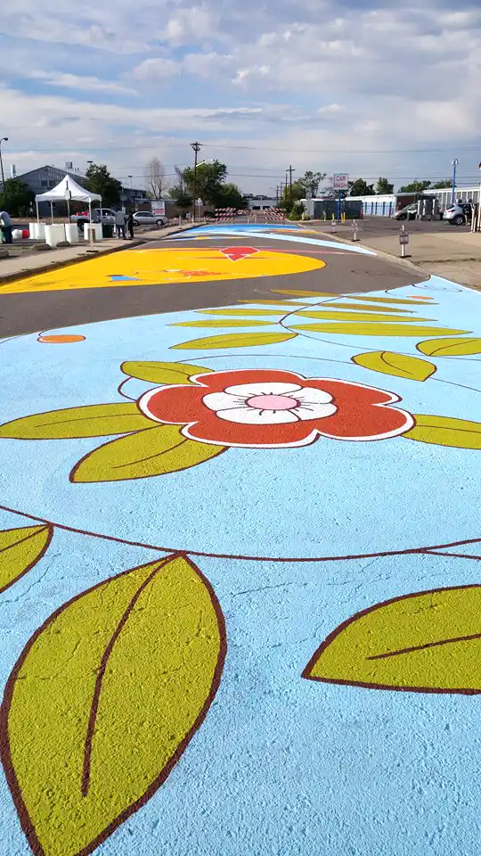 Close-up detail of painted asphalt mural showing graphic elements and street-marking paint texture.