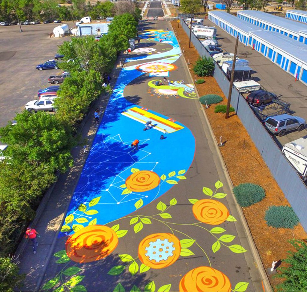 Large-scale ground mural spanning two city blocks in Aurora, Colorado, commemorating Stanley Aviation with bold graphic elements painted on asphalt.